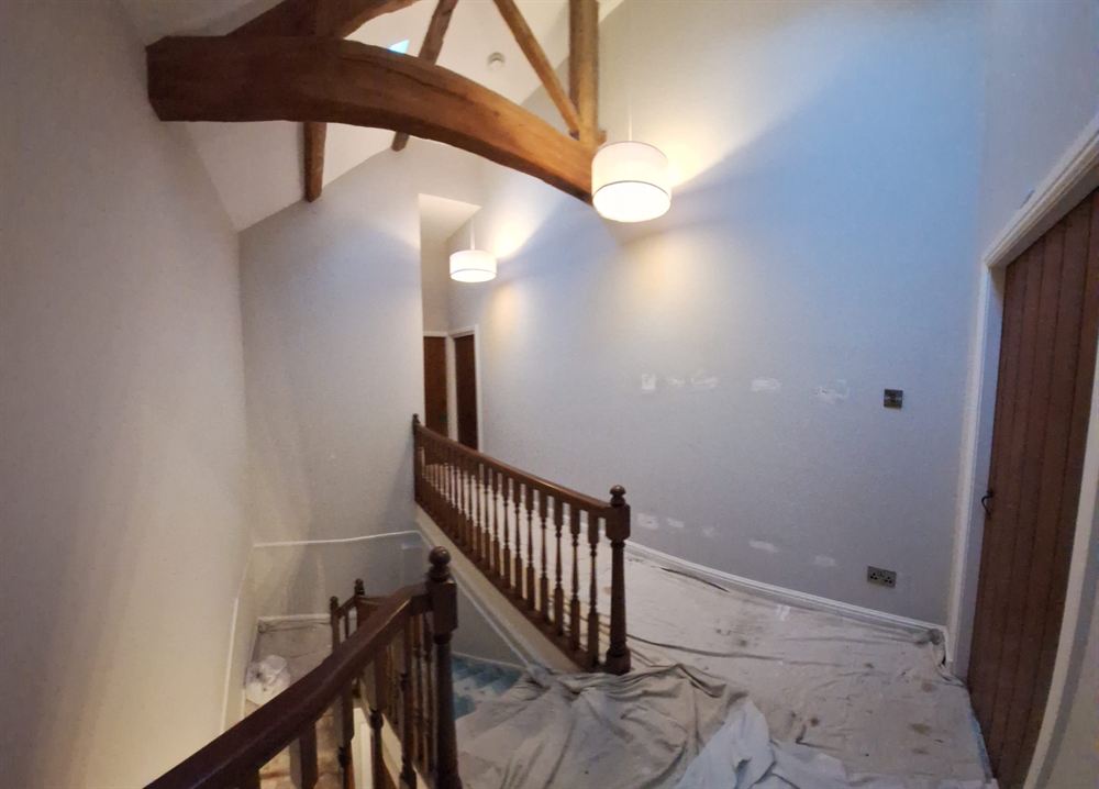 Vaulted landing part-way through decoration with dust sheets protecting the floor