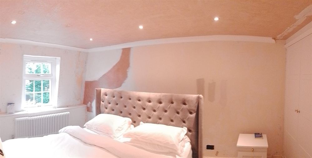 Bedroom being decorated, with filled and sanded patches ready for painting