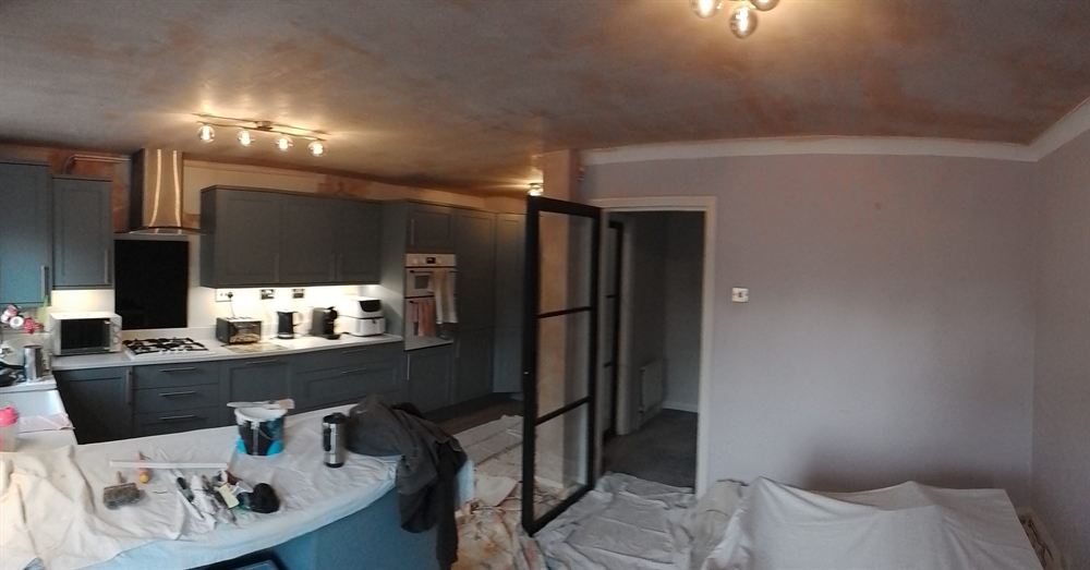 Kitchen area part-way through decoration with surfaces sheeted and protected