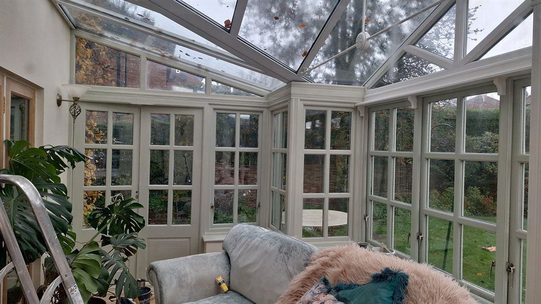 Conservatory with repainted timber frames looking out onto a garden