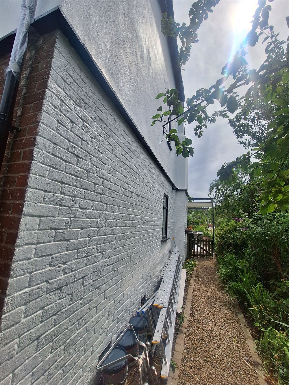 The same elevation cut back, stabilised and finished in masonry paint
