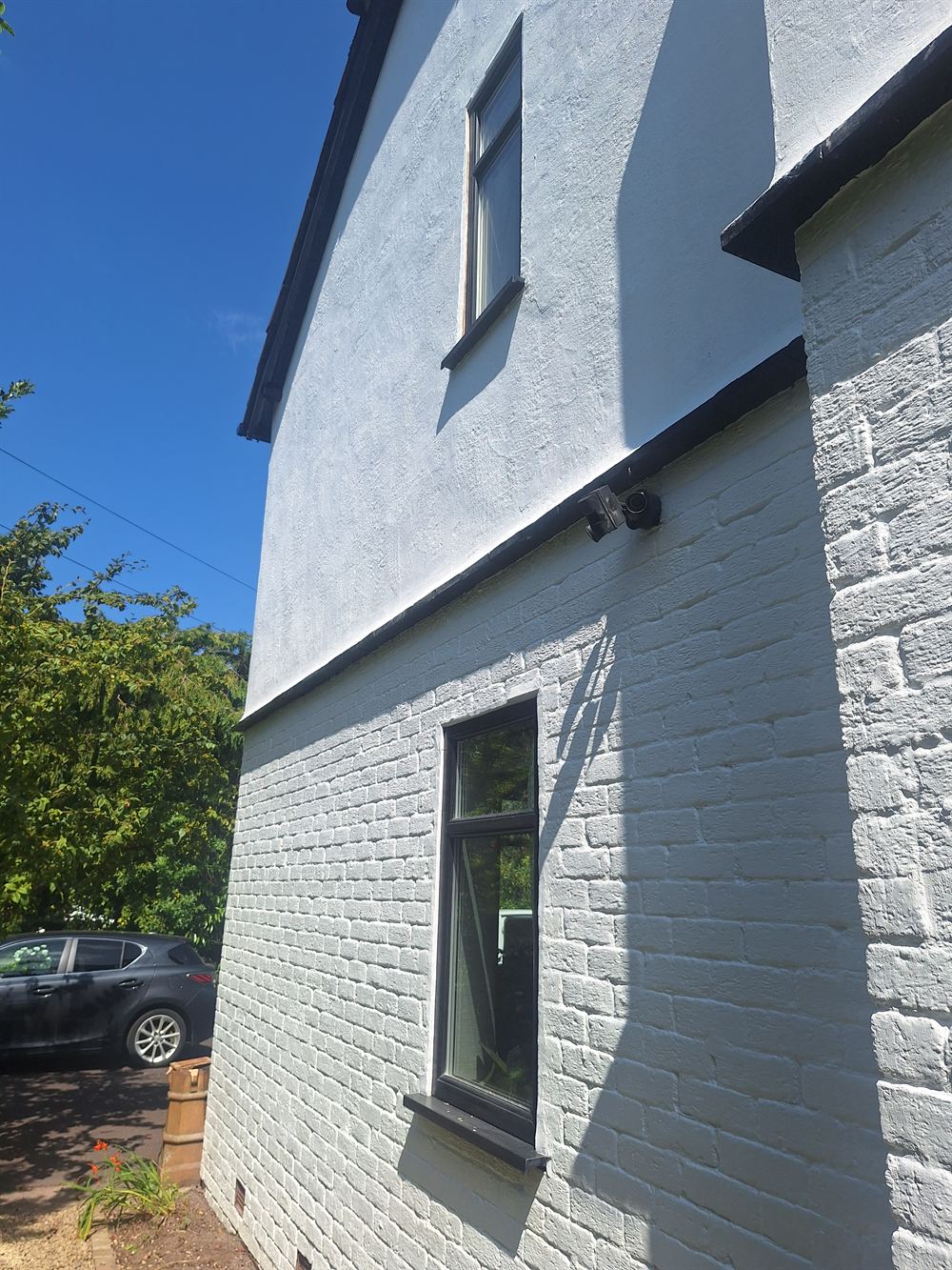 The same gable end fully prepared and repainted in a clean off-white