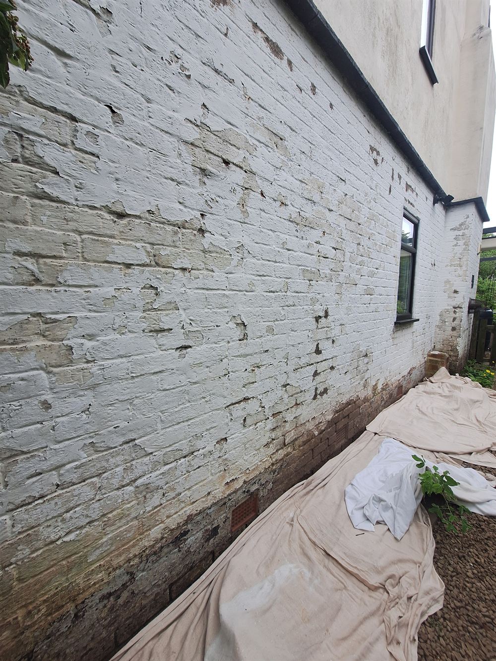 Painted brickwork flaking back to bare brick before preparation