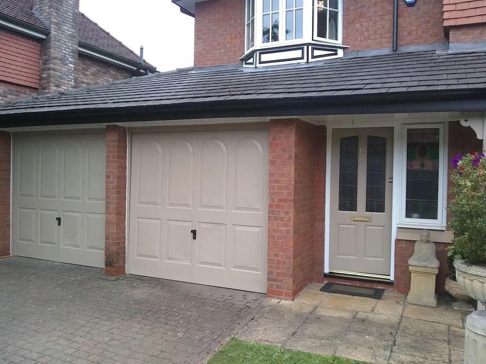 House exterior with freshly painted cream garage doors