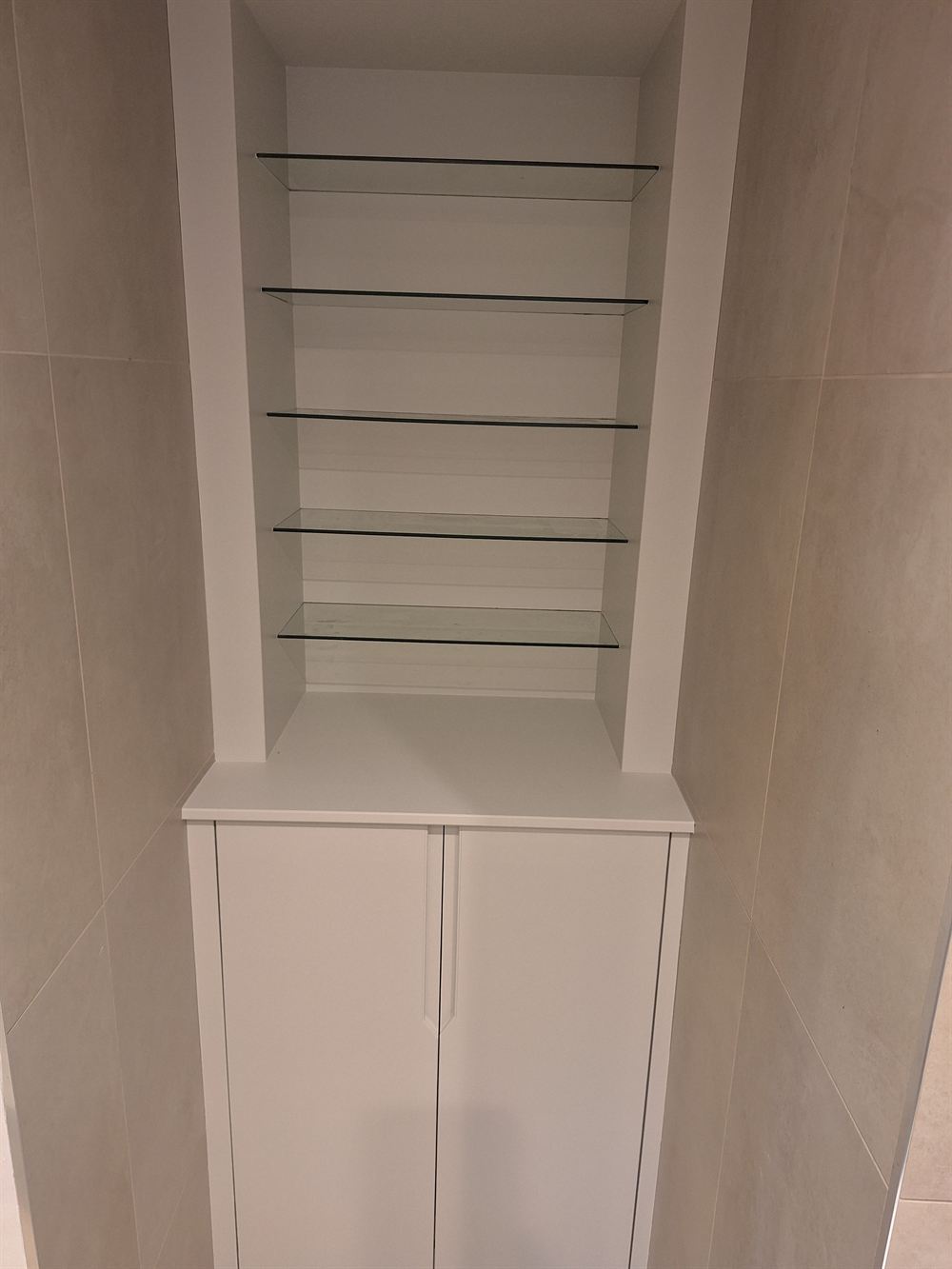 Alcove unit with glass shelving and a white cupboard, finished flat