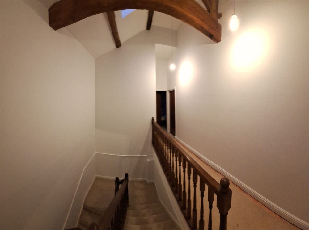 Newly decorated landing with white walls and exposed oak beams