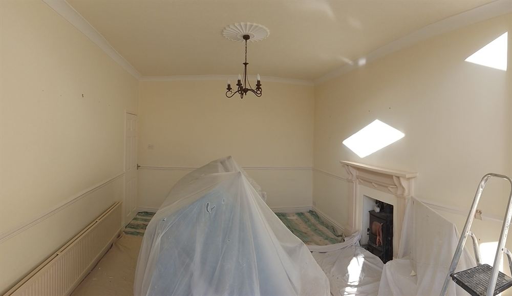 Period room mid-decoration with furniture sheeted and the fireplace protected