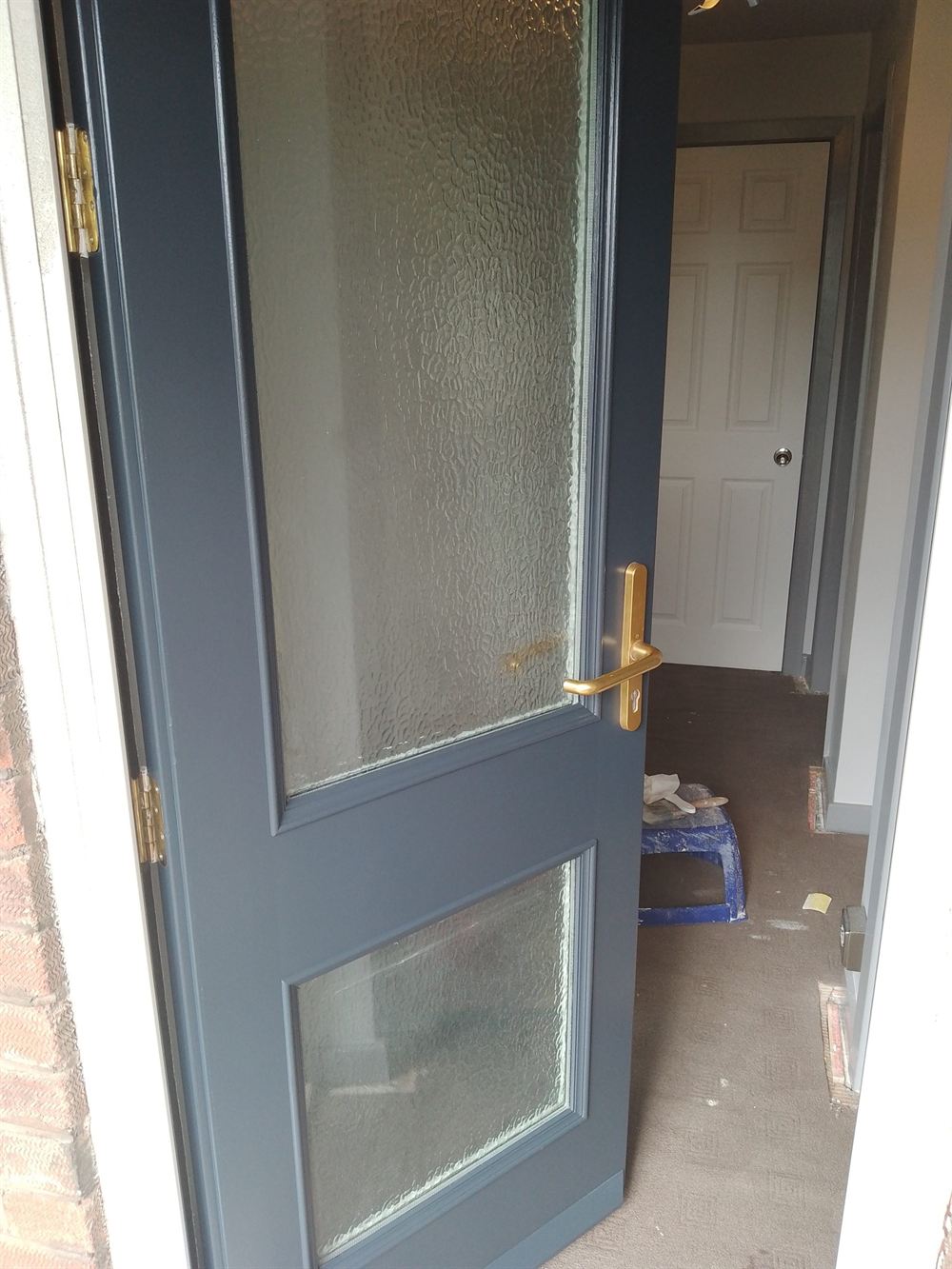 Glazed internal door finished in a flat charcoal grey with brass ironmongery